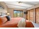Bright bedroom with a large window showing tree views, wooden sliding doors, and a mounted television at 187 Marion Dr, Evergreen, CO 80439
