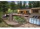 Beautiful home featuring a spacious deck, mature trees, and charming outdoor lights at 187 Marion Dr, Evergreen, CO 80439