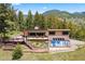 Stunning mountain home featuring a deck, hot tub, and lush landscaping at 187 Marion Dr, Evergreen, CO 80439