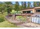 Beautiful home exterior with mature landscaping, a spacious deck, and relaxing hot tub at 187 Marion Dr, Evergreen, CO 80439