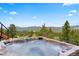Relaxing hot tub with views overlooking the lush landscape and distant mountains at 187 Marion Dr, Evergreen, CO 80439