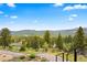 Breathtaking mountain view from a home with lush trees and clear, blue sky at 187 Marion Dr, Evergreen, CO 80439