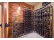 A rustic wine cellar boasts unique wooden plank walls and ample storage for a diverse wine collection at 187 Marion Dr, Evergreen, CO 80439