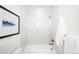 Clean bathroom with a bathtub and shower featuring white tile and modern fixtures at 1117 S Madison St, Denver, CO 80210