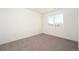 Minimalist bedroom with a large window, plush carpet, and neutral color scheme at 1117 S Madison St, Denver, CO 80210