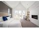Inviting main bedroom with vaulted ceilings, fireplace, and large windows showcasing the view at 1117 S Madison St, Denver, CO 80210
