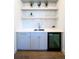 Modern wet bar includes a sink, cabinetry, shelving and a wine fridge at 1117 S Madison St, Denver, CO 80210