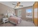 Comfortable bedroom features two windows, ceiling fan, and neutral color palette at 10567 Dartmouth, Lakewood, CO 80227