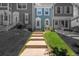 Exterior view of a charming townhome with manicured lawn and walkway leading to the front door at 10567 Dartmouth, Lakewood, CO 80227