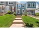 Exterior view of a charming townhome with manicured lawn and walkway leading to the front door at 10567 Dartmouth, Lakewood, CO 80227