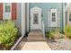 Charming front door with decorative window and light fixture, nestled amongst manicured landscaping at 10567 Dartmouth, Lakewood, CO 80227