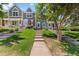 Inviting front yard featuring a walkway leading to the townhome with well-maintained lawn and landscaping at 10567 W Dartmouth Ave, Lakewood, CO 80227