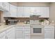 Bright kitchen featuring white cabinets, sleek appliances, and ample counter space for cooking at 10567 Dartmouth, Lakewood, CO 80227