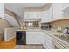 Well-organized kitchen with white cabinetry, modern appliances, and easy access to the staircase at 10567 Dartmouth, Lakewood, CO 80227