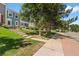 Exterior view of a charming townhome with manicured lawn and walkway leading to the front door at 10567 Dartmouth, Lakewood, CO 80227