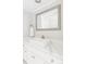Bathroom with a white basin sink, a quartz countertop, and a decorative mirror at 4530 S Verbena St # 316, Denver, CO 80237