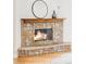 Close-up of a charming stone fireplace with a wooden mantel, adding warmth and character to the living space at 4530 S Verbena St # 316, Denver, CO 80237