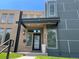 Modern home showcasing a brick and gray paneled facade with a covered entryway and manicured front lawn at 4351 Yates St, Denver, CO 80212