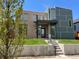 Contemporary home with a brick and gray exterior, green lawn, and a covered front entrance at 4351 Yates St, Denver, CO 80212