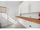 Functional laundry room featuring custom white cabinets, a butcher block countertop, and ample storage at 4351 Yates St, Denver, CO 80212