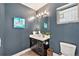 Stylish powder room with dark blue walls, modern vanity, and decorative artwork at 4351 Yates St, Denver, CO 80212