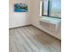 Minimalist bedroom with wood laminate flooring, accent window, flat-screen TV, and an air conditioning unit at 603 Inca St # 429, Denver, CO 80204