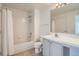 Well-lit bathroom featuring a tiled shower and tub, a single sink vanity, and neutral tile flooring at 7440 S Blackhawk St # 4-102, Englewood, CO 80112