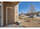 View of the front door showing the entryway, stone detail, and parking area at 7440 S Blackhawk St # 4-102, Englewood, CO 80112