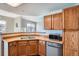 Kitchen featuring tile countertops, natural wood cabinets, and stainless steel appliances at 7440 S Blackhawk St # 4-102, Englewood, CO 80112