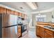 Bright kitchen with stainless appliances, tile countertops, and natural wood cabinets at 7440 S Blackhawk St # 4-102, Englewood, CO 80112