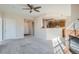 Open-concept living area featuring a cozy fireplace, a partial wall to the kitchen and carpeted floors at 7440 S Blackhawk St # 4-102, Englewood, CO 80112
