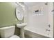 Bathroom with a shower over tub and white fixtures with glass block window adding natural light at 1691 Poplar St, Denver, CO 80220