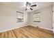 Light-filled bedroom featuring hardwood floors, a ceiling fan, and two windows at 1691 Poplar St, Denver, CO 80220