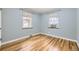 Bright bedroom with hardwood floors, neutral walls, and natural light from the two windows at 1691 Poplar St, Denver, CO 80220