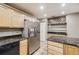 Well-equipped kitchen featuring stainless steel refrigerator, granite counters, and wooden cabinets at 1691 Poplar St, Denver, CO 80220