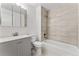Bathroom with a shower-tub combo with light-colored tile, updated vanity and mirror at 11542 Community Center Dr # 56, Northglenn, CO 80233