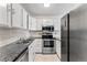 Stylish kitchen boasting granite countertops, stainless steel appliances, and white cabinets for a modern touch at 11542 Community Center Dr # 56, Northglenn, CO 80233