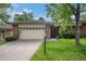 Charming brick home featuring a well-maintained lawn, mature tree, and attached two-car garage at 8022 W 78Th Way, Arvada, CO 80005