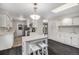 Bright kitchen featuring white cabinets, stainless steel appliances, an island, and sleek hardwood flooring at 8022 W 78Th Way, Arvada, CO 80005