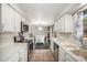 Bright kitchen features white cabinets and modern appliances with an open view to the living room at 8022 W 78Th Way, Arvada, CO 80005