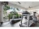 Bright community fitness center with modern treadmills and floor-to-ceiling windows overlooking lush landscaping at 9963 E Carolina Cir # 104, Aurora, CO 80247