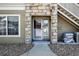 Inviting condo front door with stone detail, an ADT security system and an exterior stairway at 9963 E Carolina Cir # 104, Aurora, CO 80247