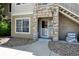 Welcoming condo front door with stone details and exterior stairway access at 9963 E Carolina Cir # 104, Aurora, CO 80247