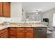 Granite countertops and stainless steel dishwasher with view to living room at 9963 E Carolina Cir # 104, Aurora, CO 80247