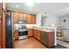 Well-lit kitchen featuring stainless steel appliances, granite countertops, and wooden cabinets at 9963 E Carolina Cir # 104, Aurora, CO 80247