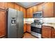 Stainless steel appliances including refrigerator and range with wood cabinets at 9963 E Carolina Cir # 104, Aurora, CO 80247