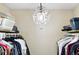 Organized walk-in closet with ample hanging space and a glamorous chandelier lighting the space at 9963 E Carolina Cir # 104, Aurora, CO 80247