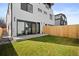 Grassy backyard with a wood fence and sliding glass doors leading into the modern home at 4238 Zuni St, Denver, CO 80211
