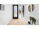 Bright entryway with sleek black door and large windows, complemented by a stylish console and circular mirror at 4238 Zuni St, Denver, CO 80211