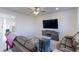 Bright living room with hardwood floors, modern ceiling fan, and large TV mounted on the wall at 9448 Richfield St, Commerce City, CO 80022